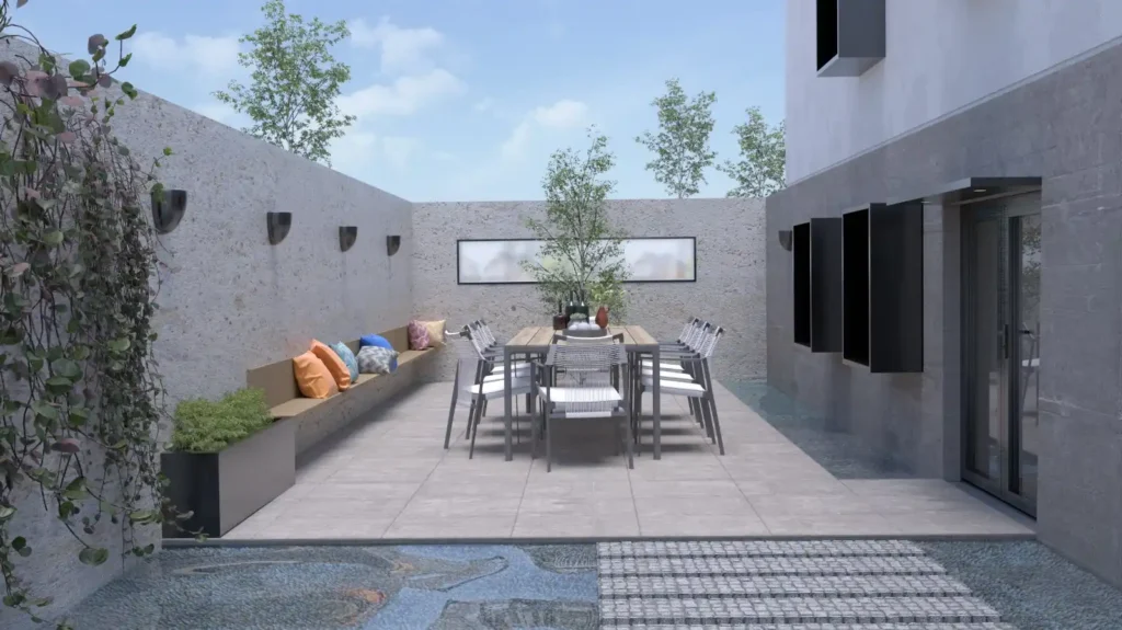 Imagem de projeto arquitetônico, de uma area externa, com paredes cinzas com banco de madeira de esrtutura fixa na parede para seis pessoas, com almofadas coloridas. Mesa cinza para dez pessoas. 