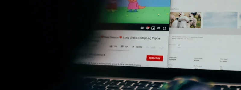 sombra de uma pessoa do lado esquerda a assistir ao desenho animado "Peppa Pig" no computador.