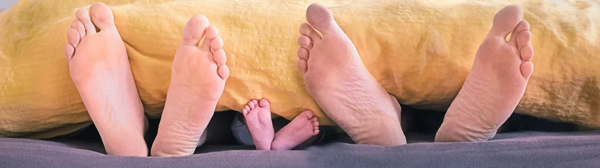 Imagem de pés para fora do cobertor.